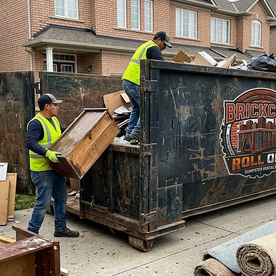 The BrickCity Roll Off crew loading renovation debris into a roll-off container on a driveway